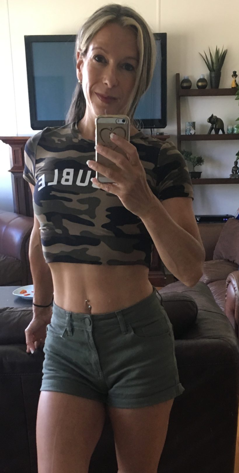 Annie Légaré après sa transformation, en t-shirt court et en short, la silhouette tonique, photographiée devant un miroir