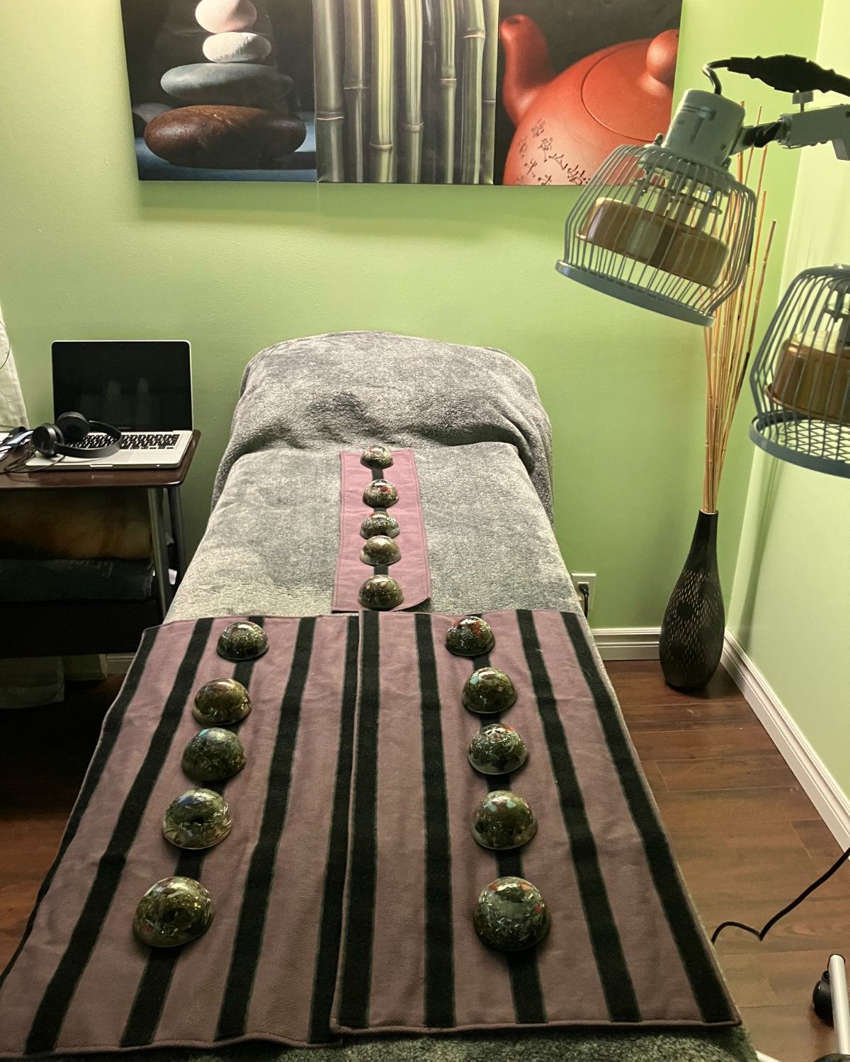 La salle de soins d&rsquo;Annie Légaré à Québec : la table du Med Bed, recouverte de bandes violettes où reposent des modules de quartz, sous deux lampes, contre un mur vert tendre